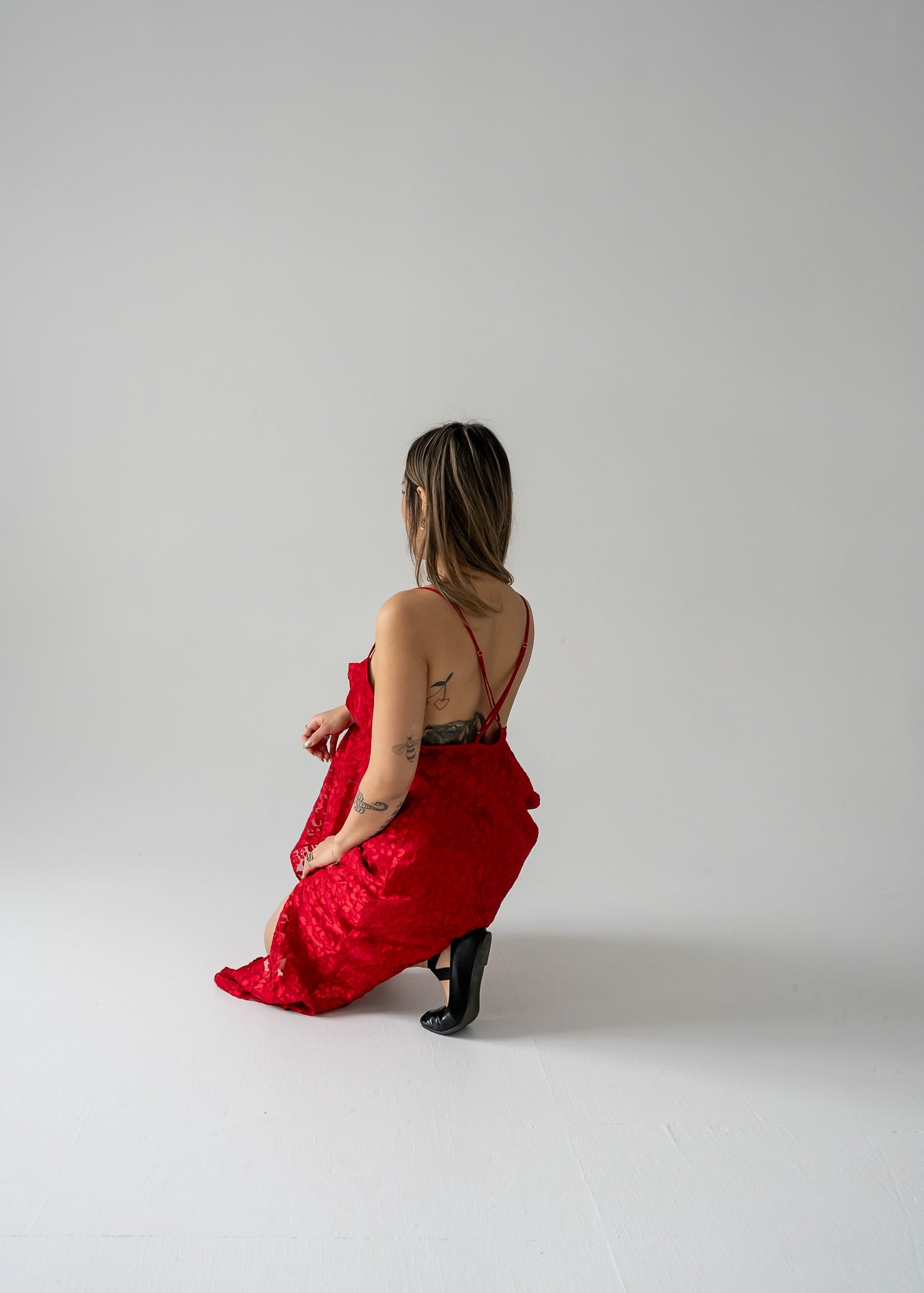 A model wearing a cherry red sheer floral burnout cowl neck thin strap dress