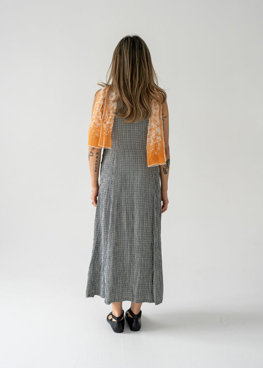 A person wearing an orange and cream sheer chiffon scarf with a small floral pattern, with their back towards the camera.