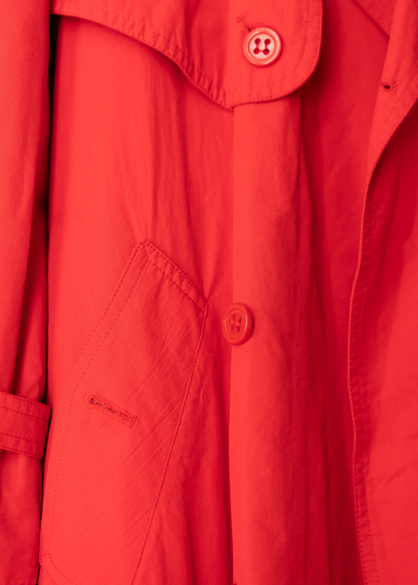 close up of a vintage cherry red double breasted button up belted full length trench coat.