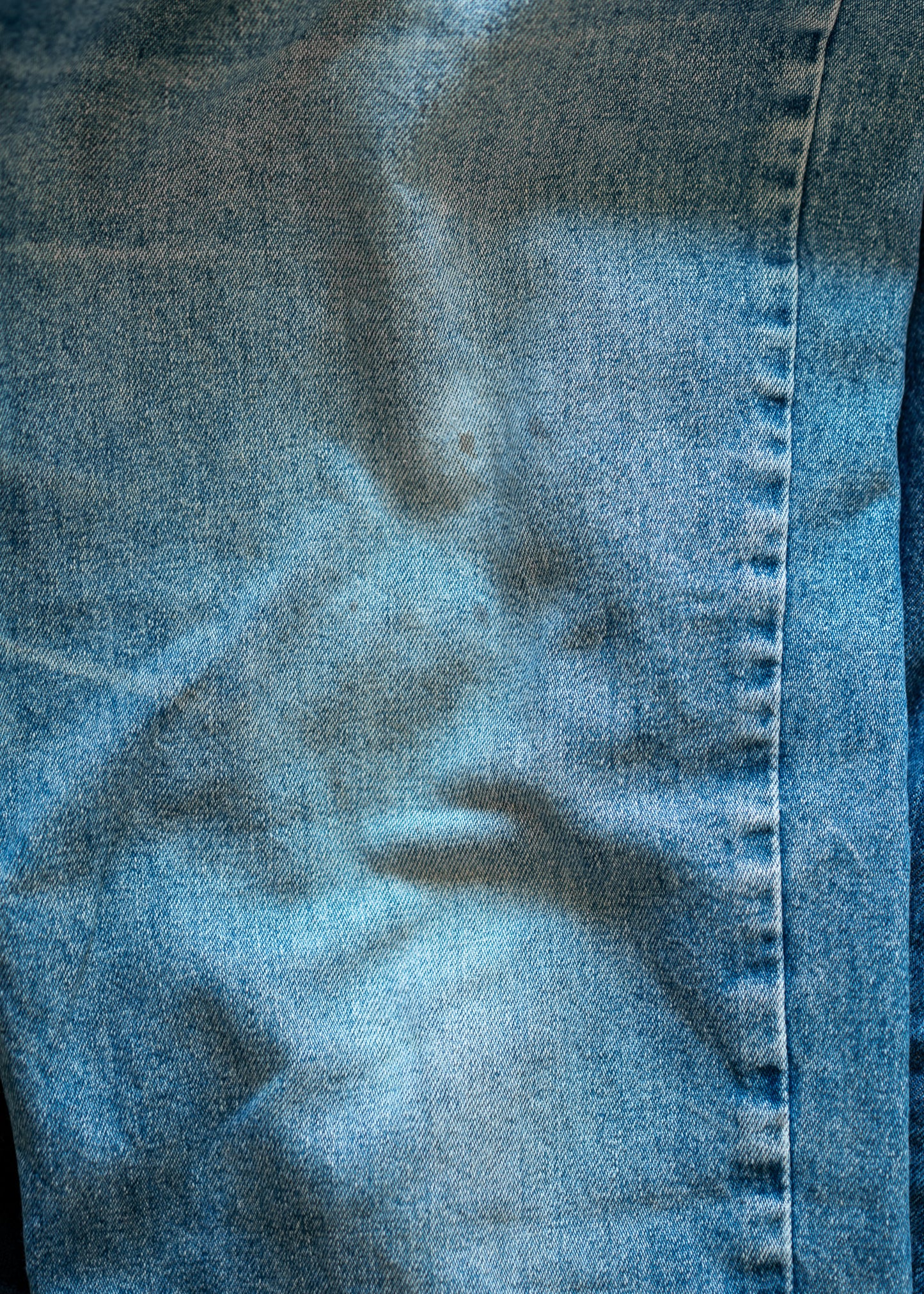 Close-up of blue denim fabric with stitching detail