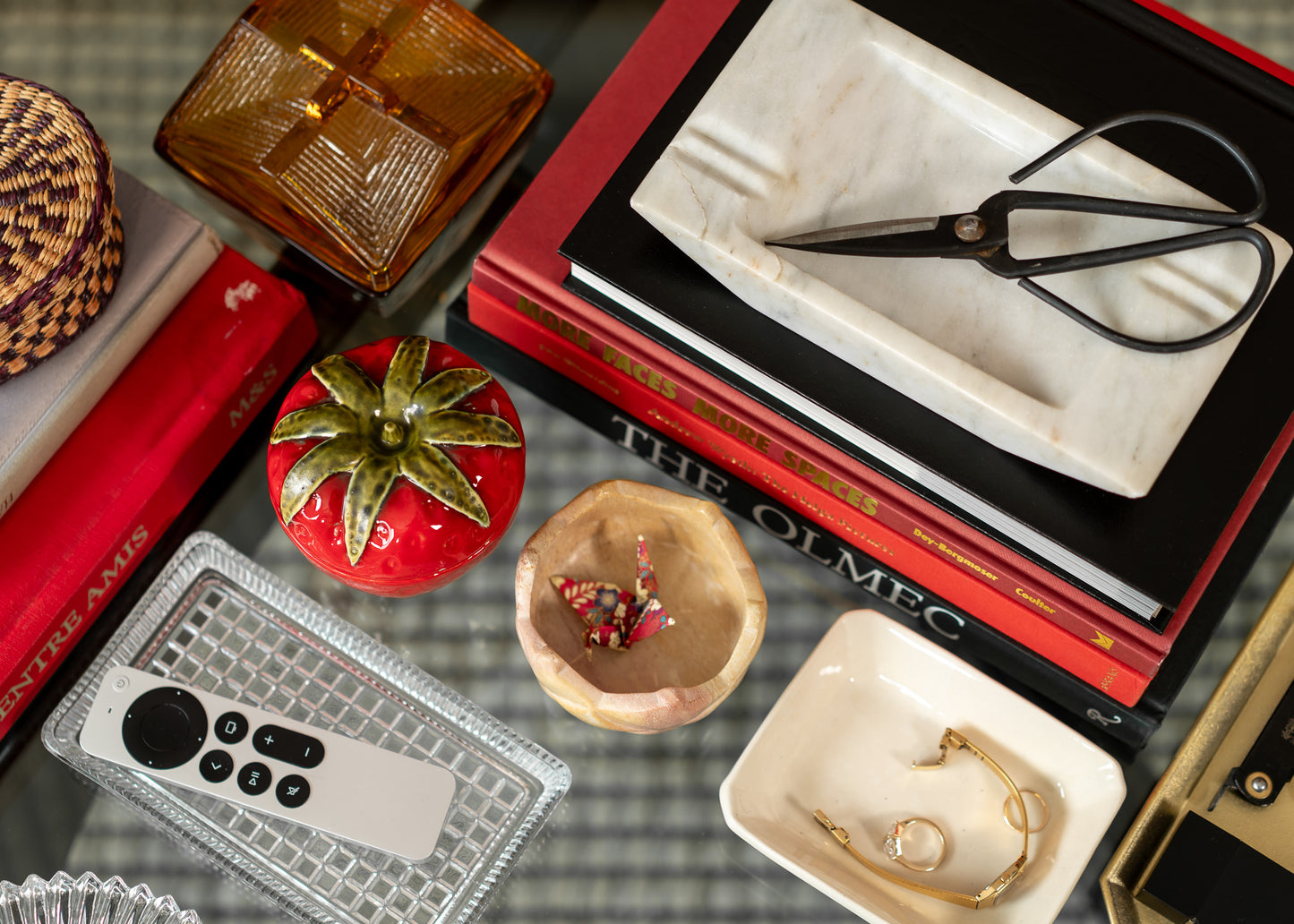 Collection of small vintage decorative items on a textured surface with books and a remote control.