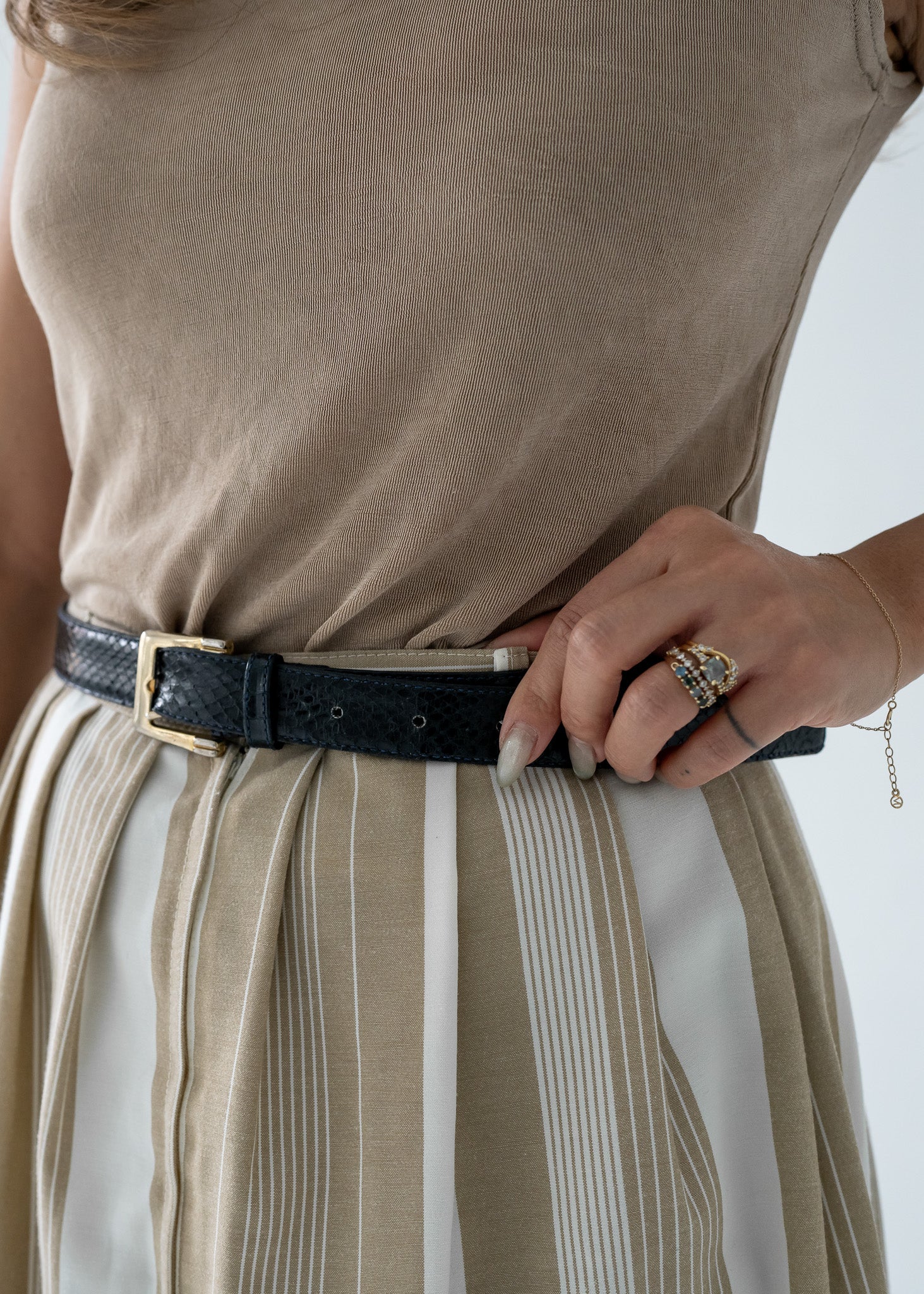 detail shot of a vintage navy blue snakeskin belt with gold buckle