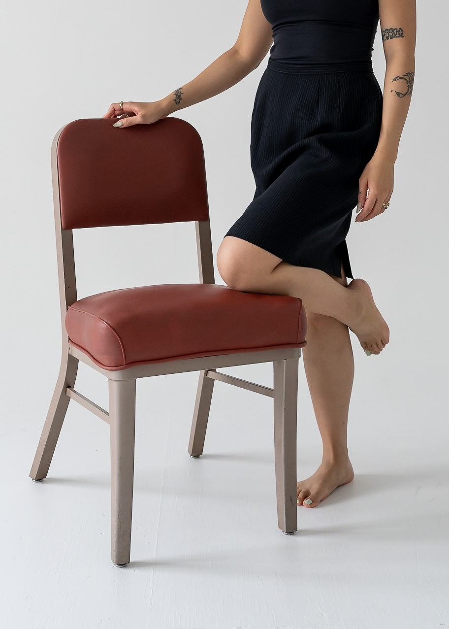 A person resting on a chair with a vintage fitted A-line mini skirt in black and white stripes
