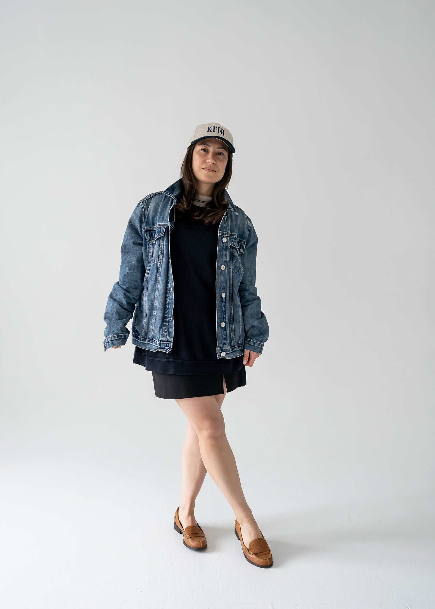 Person wearing a denim jacket and vintage navy and taupe Oscar de la Renta long sleeve pullover shirt on a white background