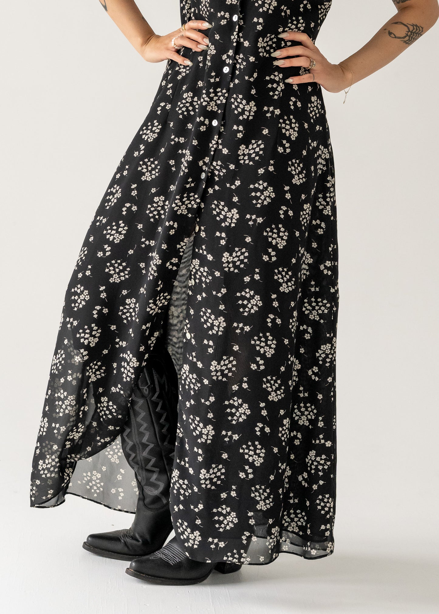 close up shot of a vintage black and cream small print floral ruffle neck button up cap sleeve maxi dress