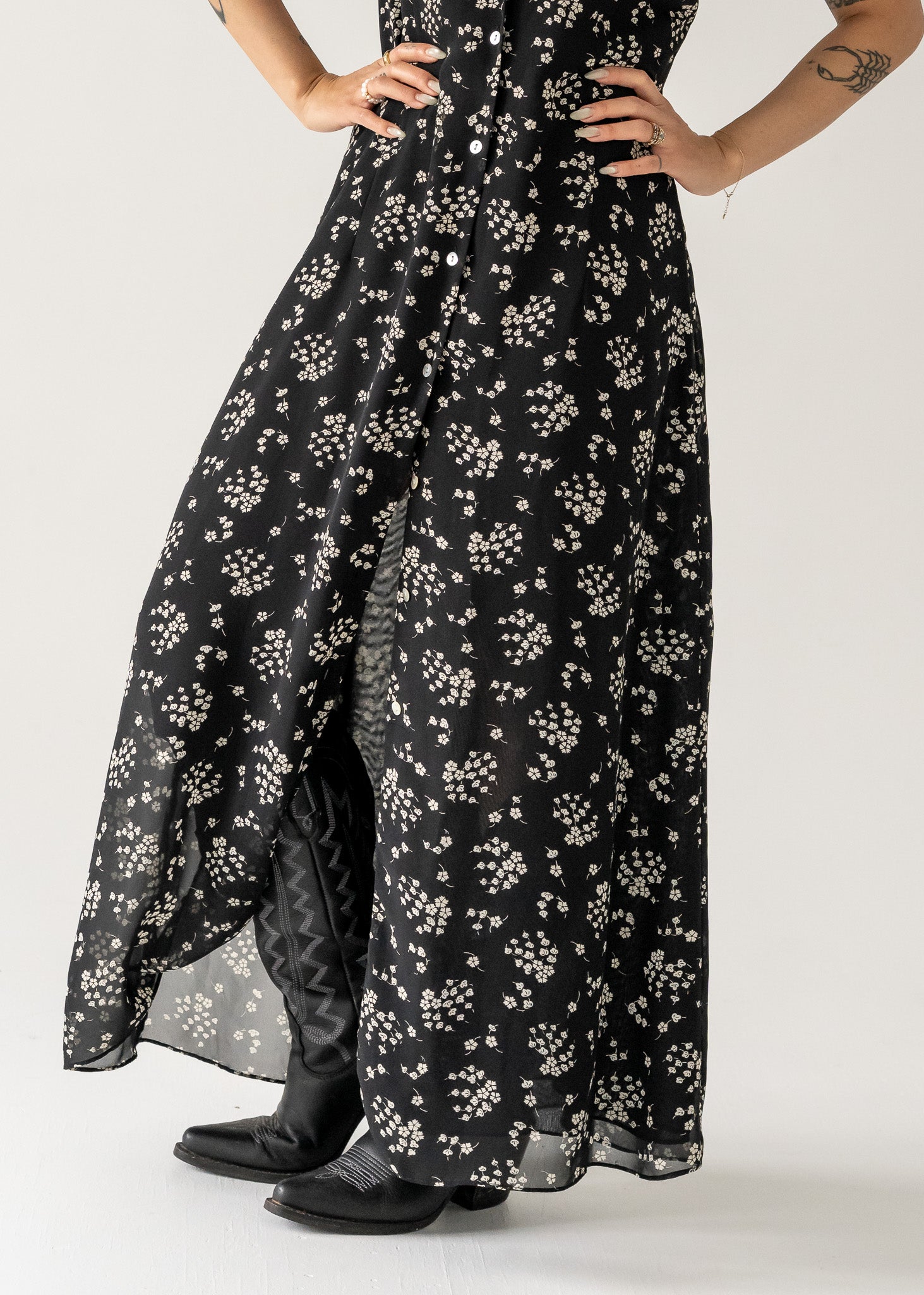 close up shot of a vintage black and cream small print floral ruffle neck button up cap sleeve maxi dress