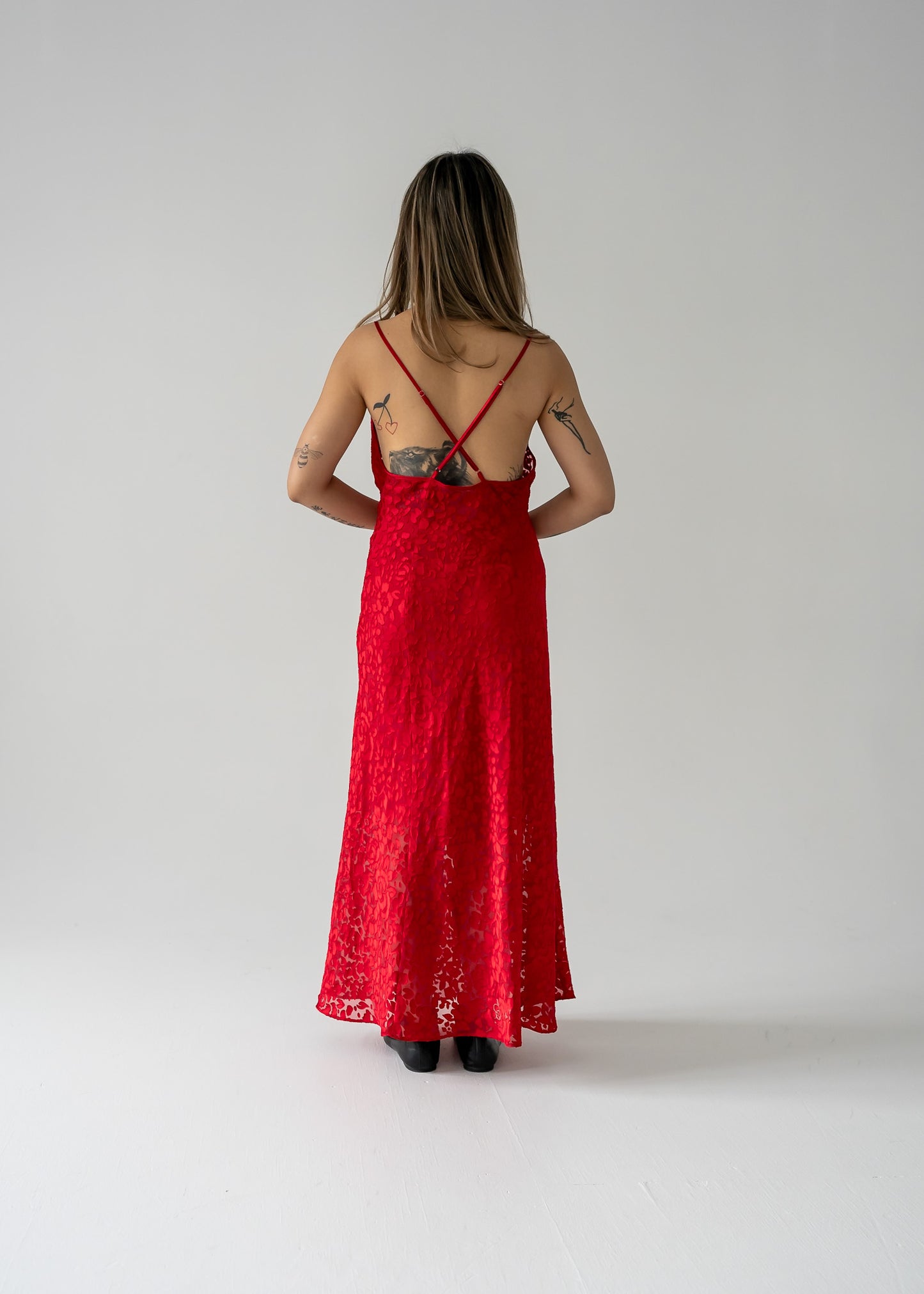 A model wearing a cherry red sheer floral burnout cowl neck thin strap dress 