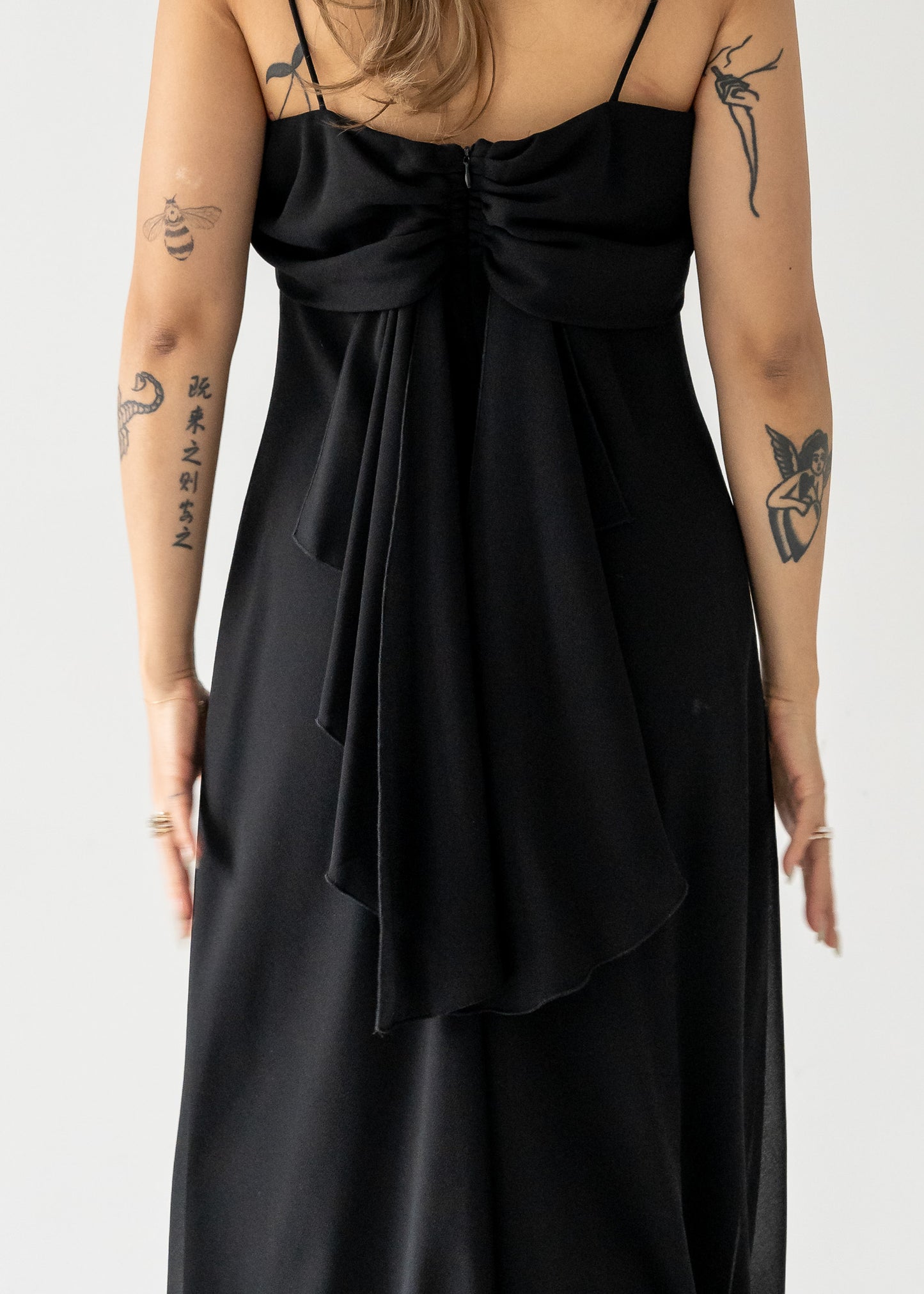 Vintage black dress with a tie detail on a plain background