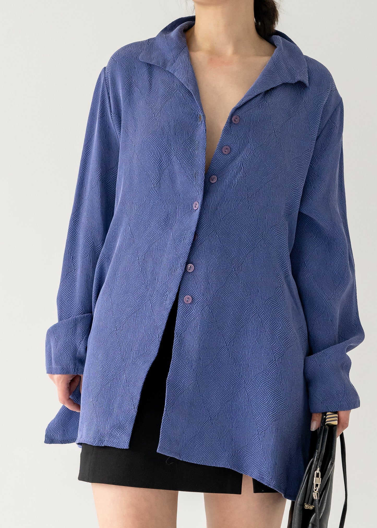 textured long vintage violet collared button front blouse worn by a person against a white background.