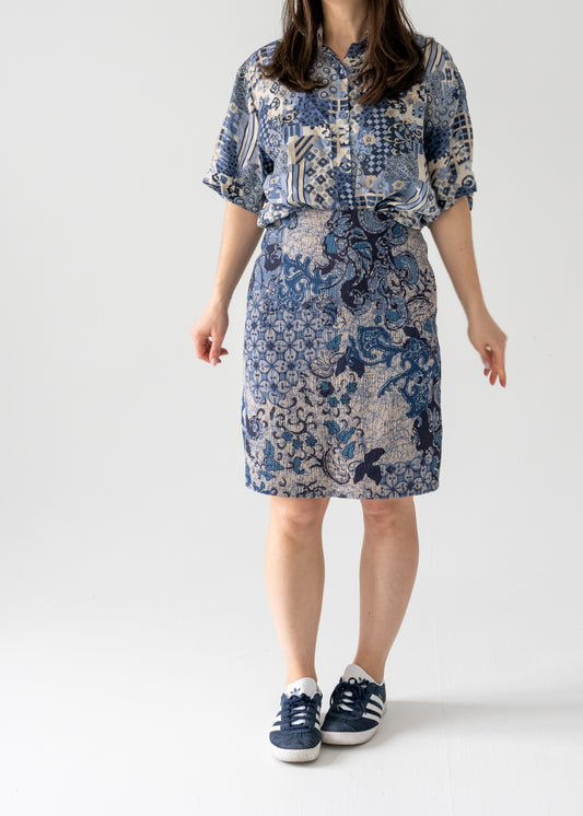 A model wearing a knee-length blue floral pattern vintage pencil skirt with a shirt dress style top.