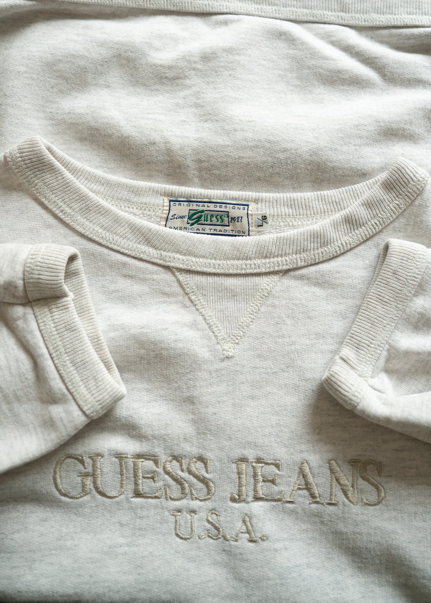 Light gray sweatshirt with 'Guess Jeans U.S.A.' embroidery on a light background