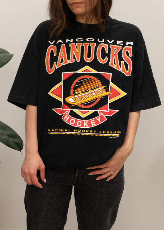 Person wearing a black Vancouver Canucks t-shirt with team logo