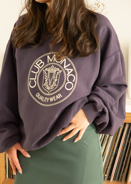 Person wearing a vintage purple Club Monaco sweatshirt with a record collection in the background
