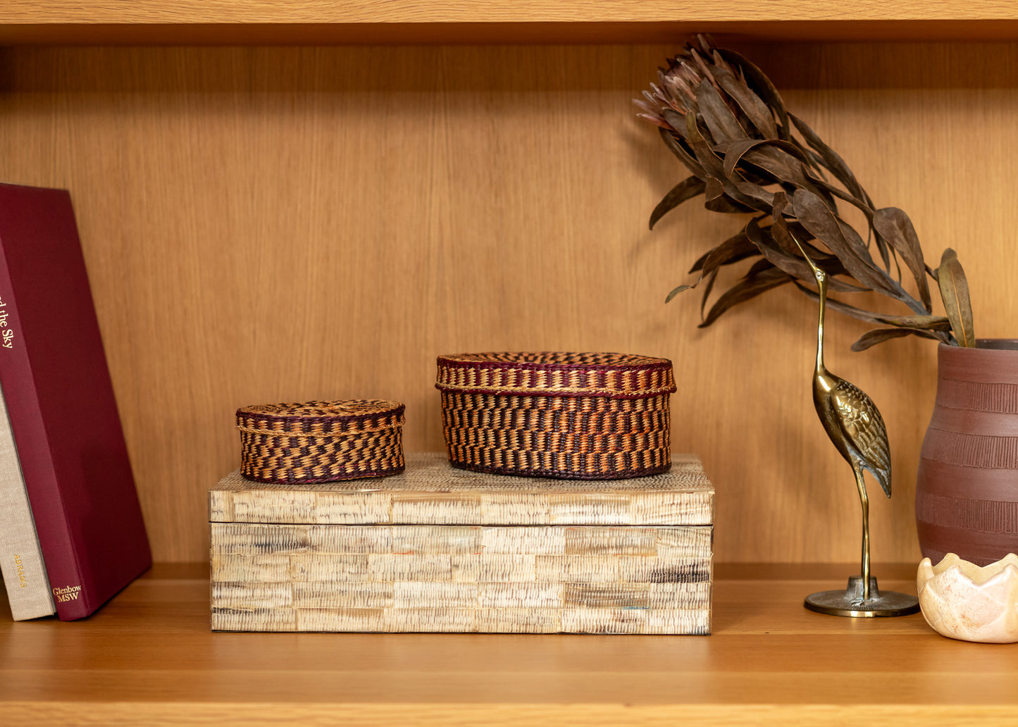 Decorative items including vintage baskets and a vase on a wooden shelf.