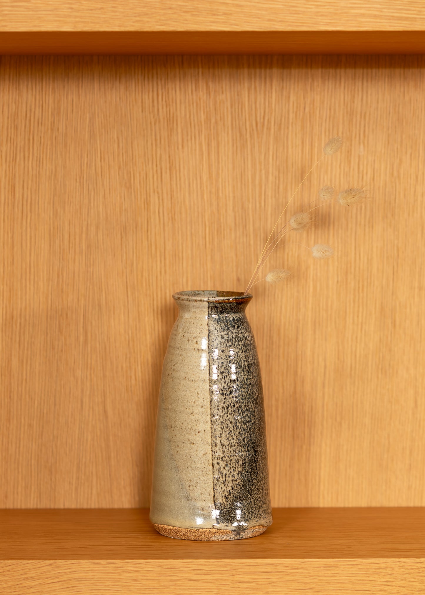 vintage brown speckled ceramic vase on a wooden shelf