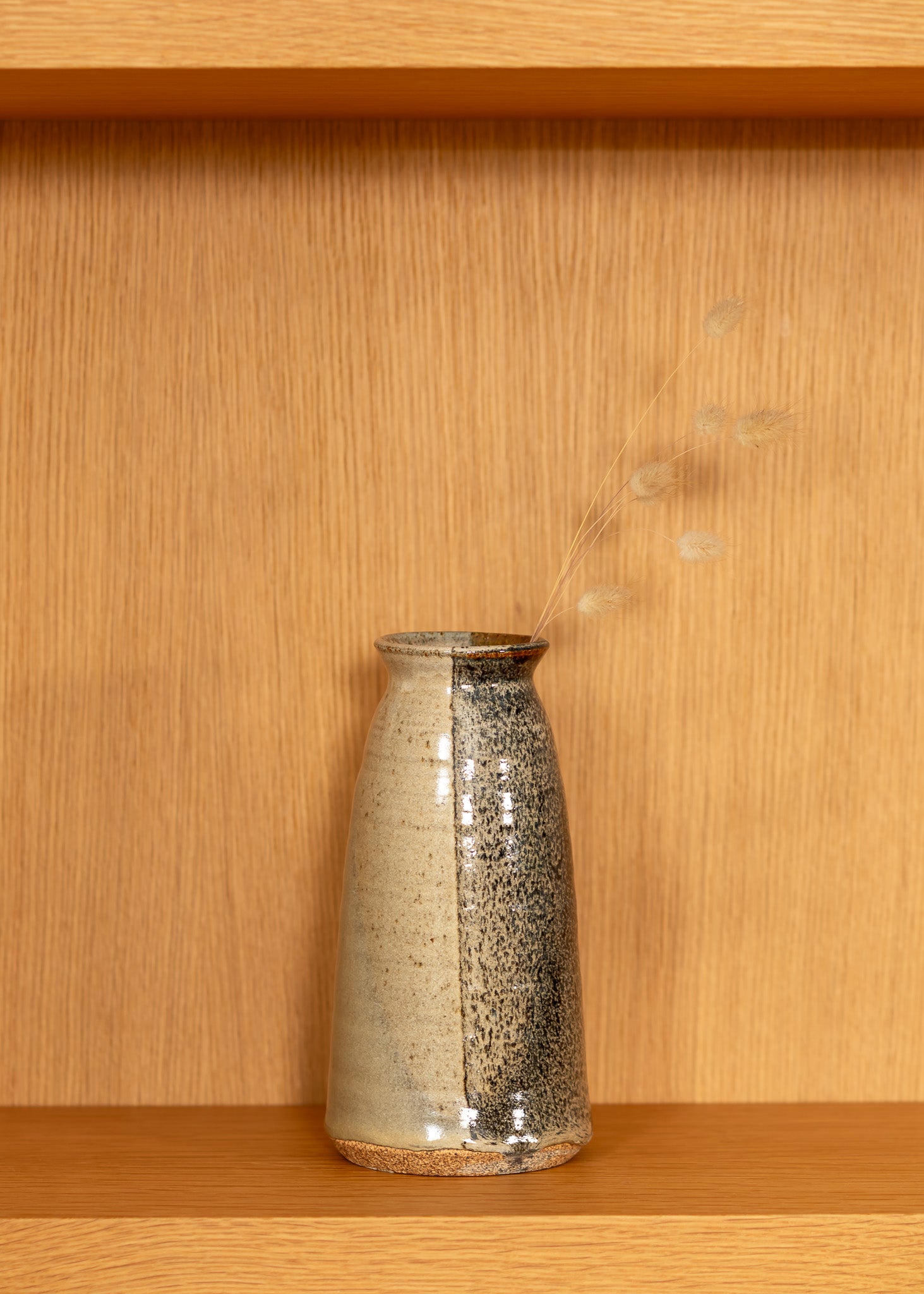 vintage brown speckled ceramic vase on a wooden shelf