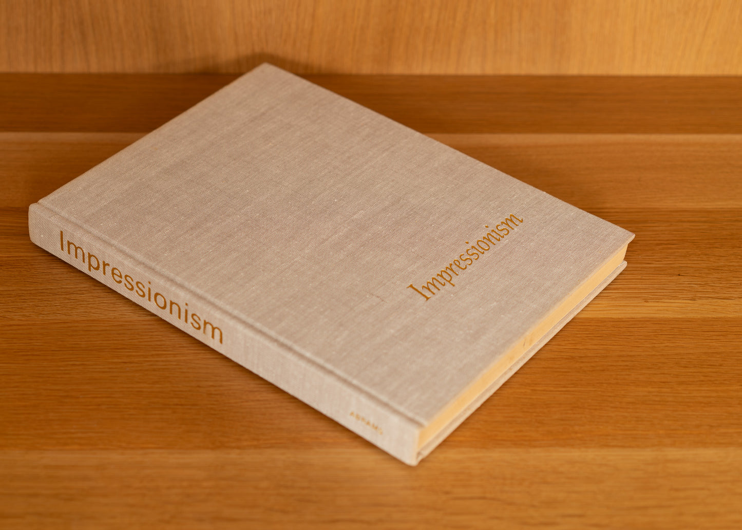 Vintage book titled 'Impressionism' on a wooden surface