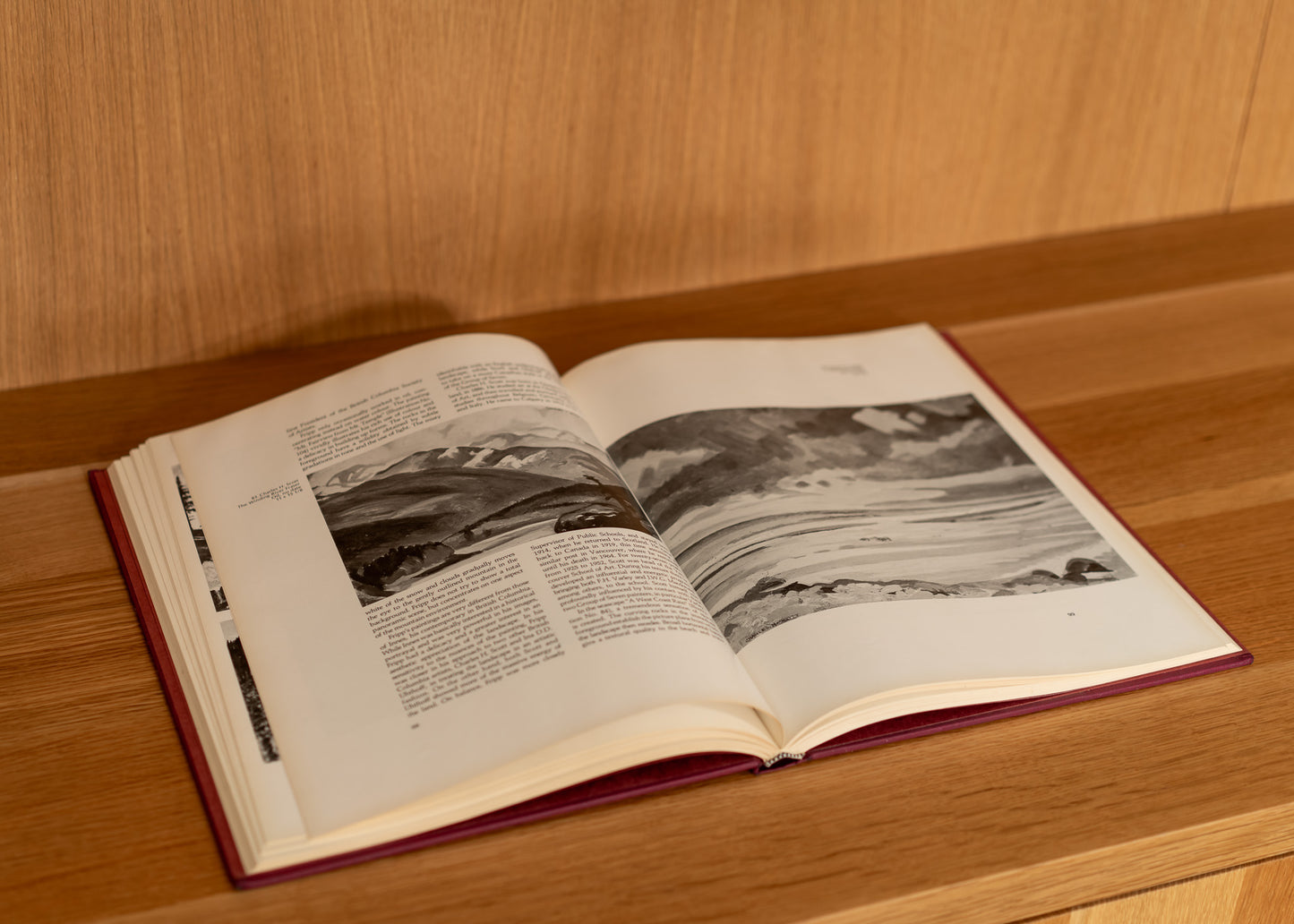 Open vintage book with black and white photographs on a wooden surface