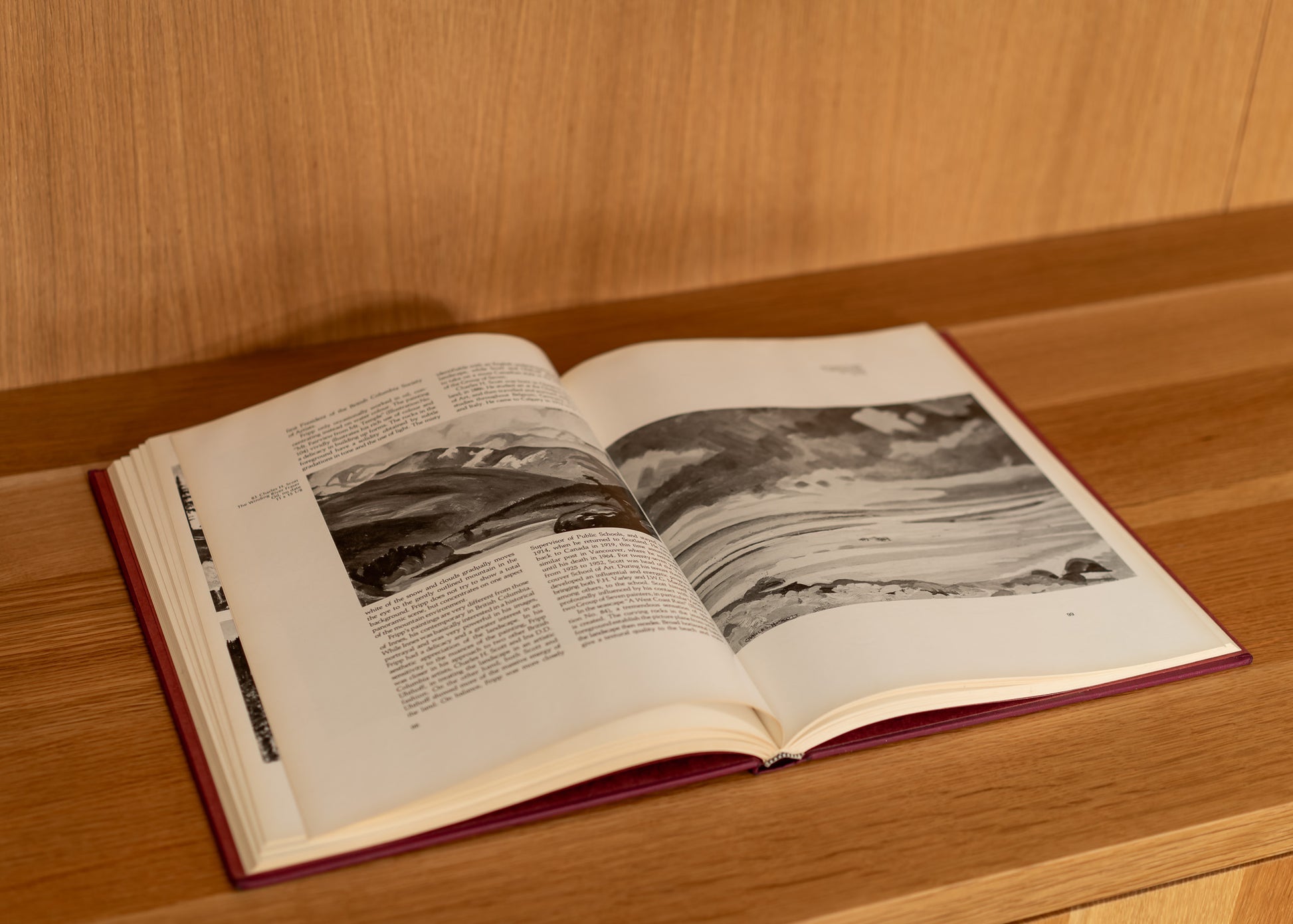 Open vintage book with black and white photographs on a wooden surface