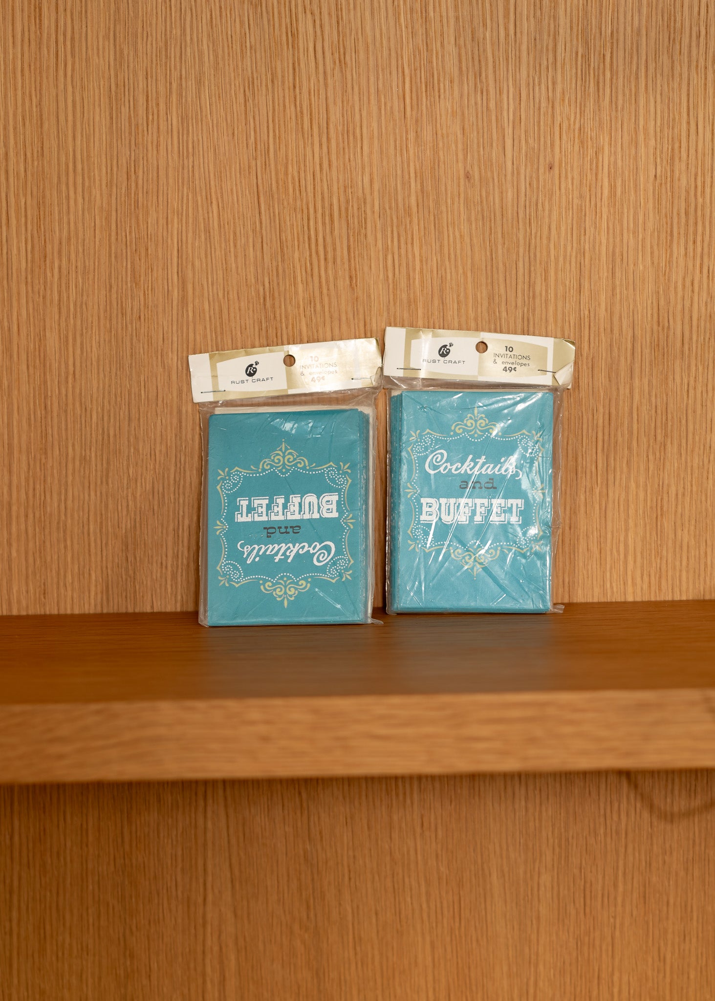 Two vintage blue packages labeled 'Buffet' and 'Cocktail Buffet' on a wooden surface.