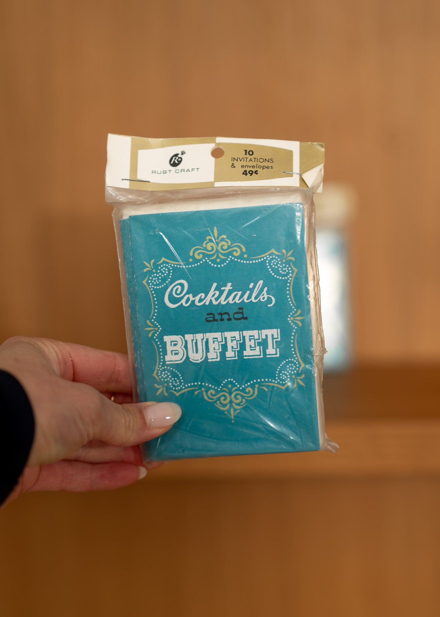 vintage packaged product with 'Cocktails and Buffet' text held by a hand against a blurred background