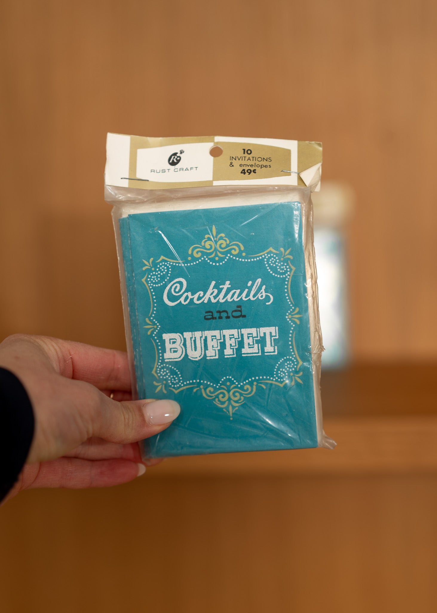 vintage packaged product with 'Cocktails and Buffet' text held by a hand against a blurred background