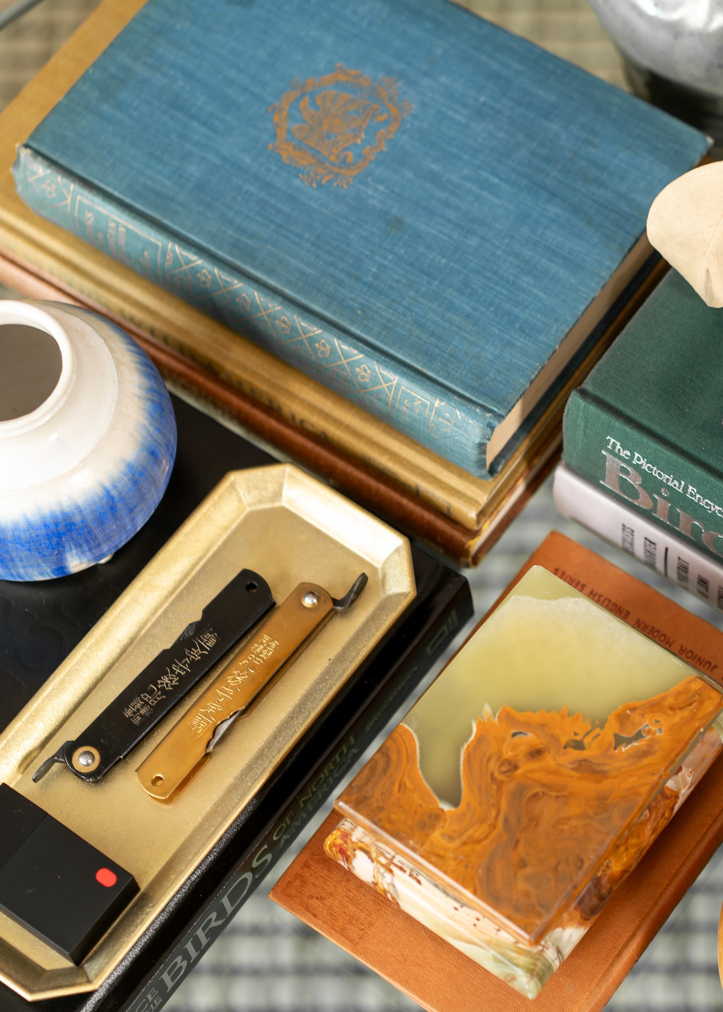 Collection of vintage books and a knife on a textured surface