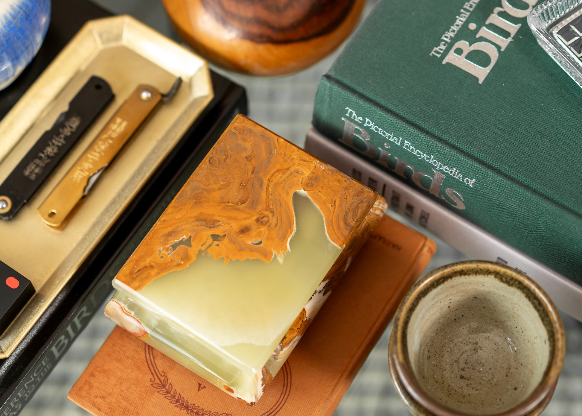 Close-up of a vintage onyx box, knife, and book on a textured surface