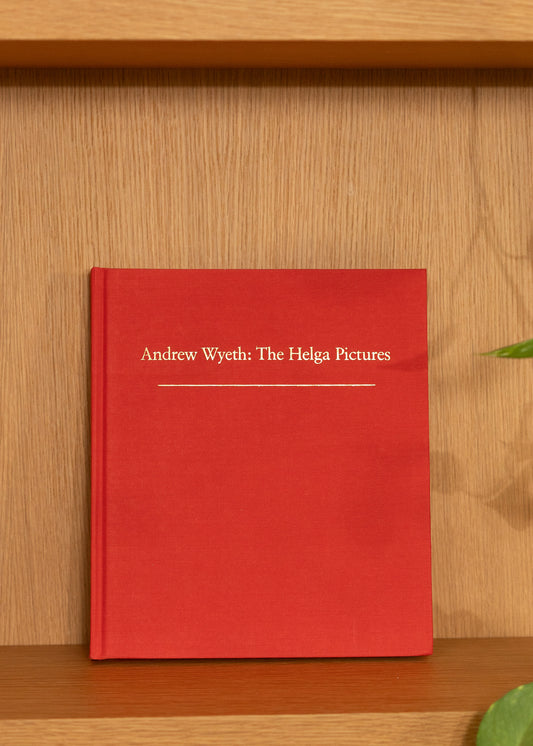 Vintage red book titled 'Andrew Wyeth: The Helga Pictures' on a wooden shelf.