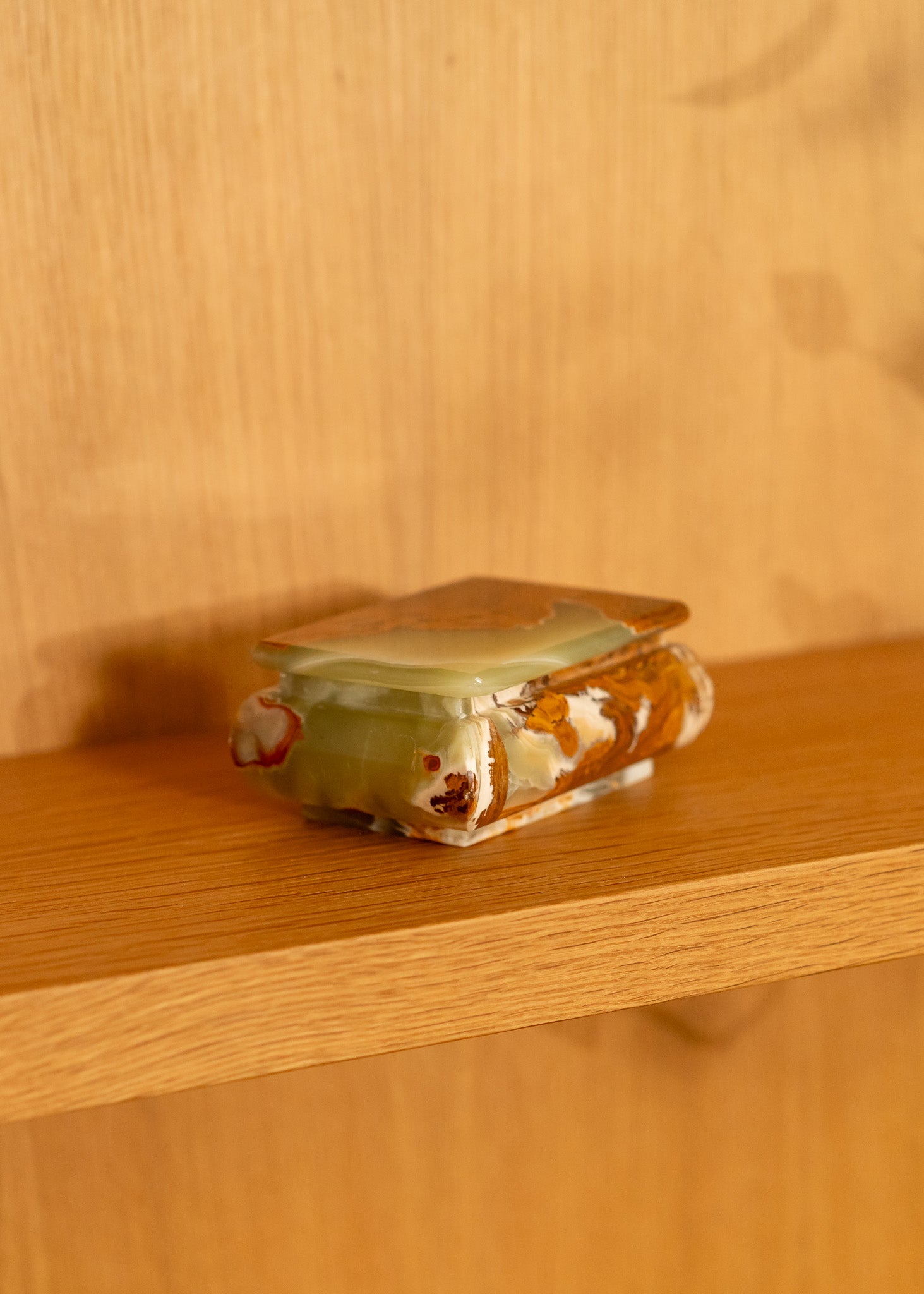 vintage onyx box with a green lid on a wooden surface