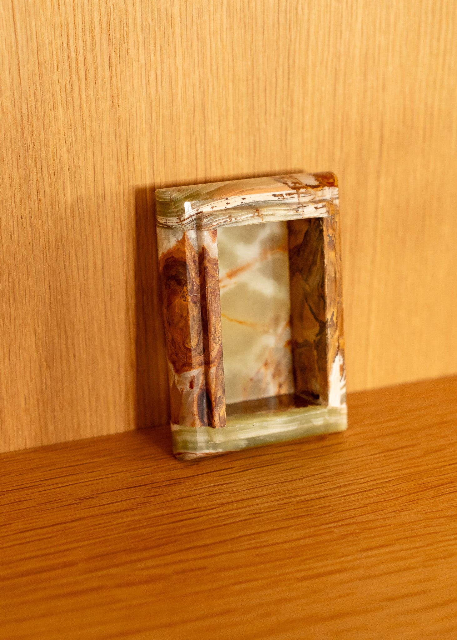 Decorative open vintage onyx box with a natural wood pattern on a wooden surface