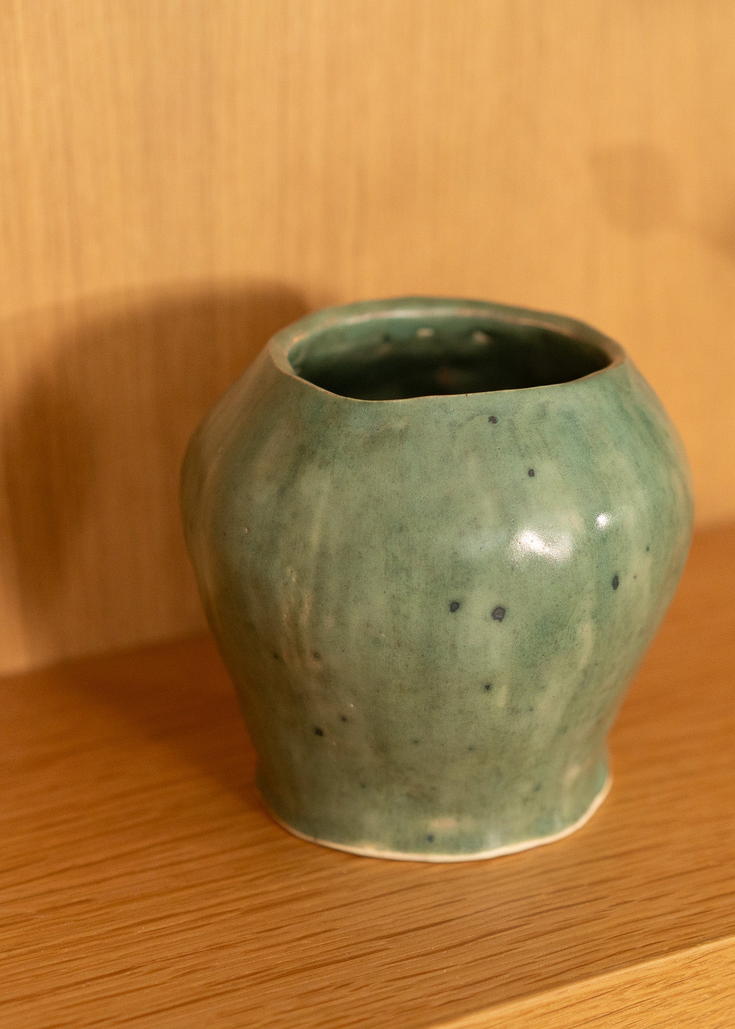 Green vintage ceramic vase on a wooden surface