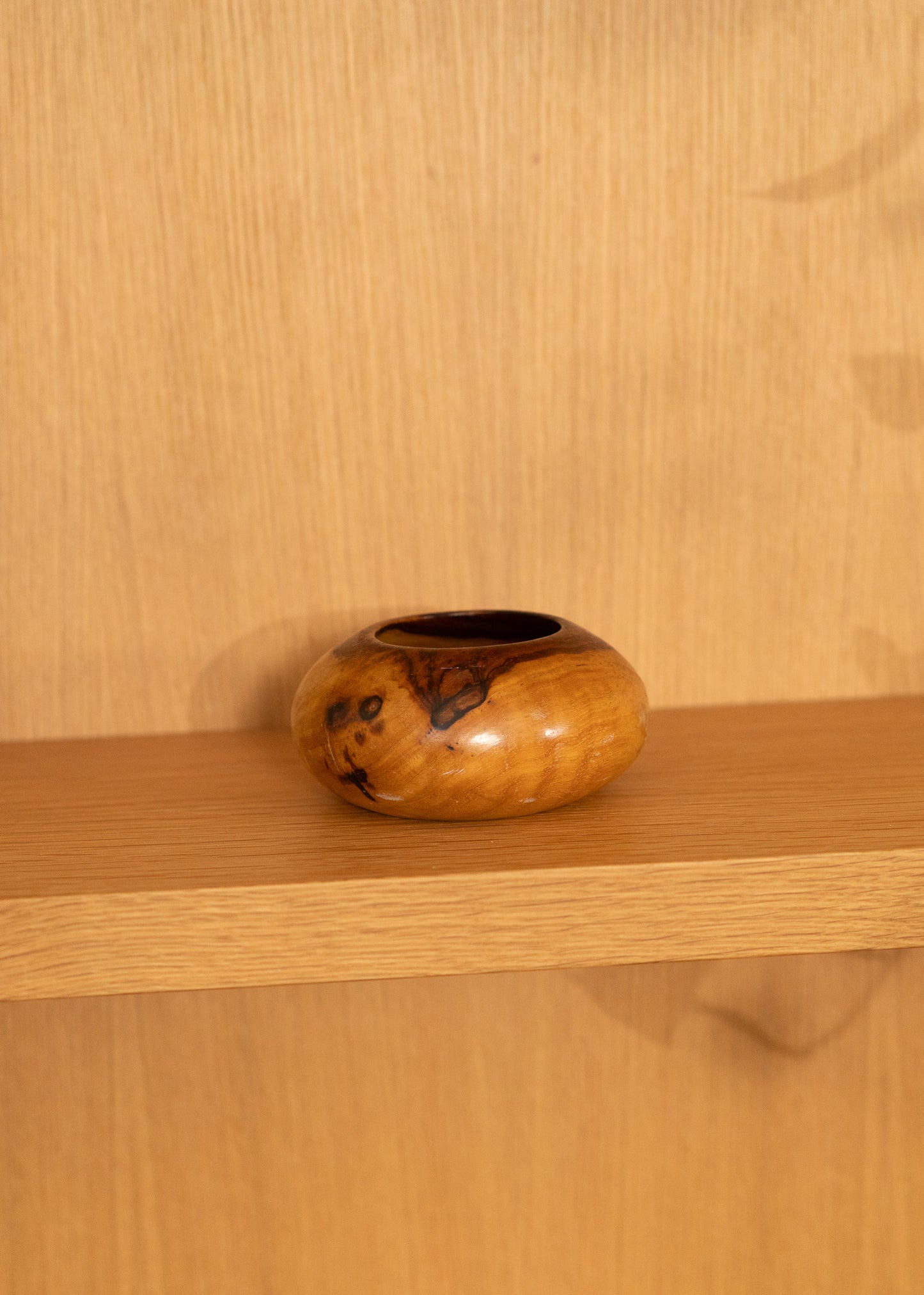 vintage wooden bowl on a wooden shelf against a wooden wall