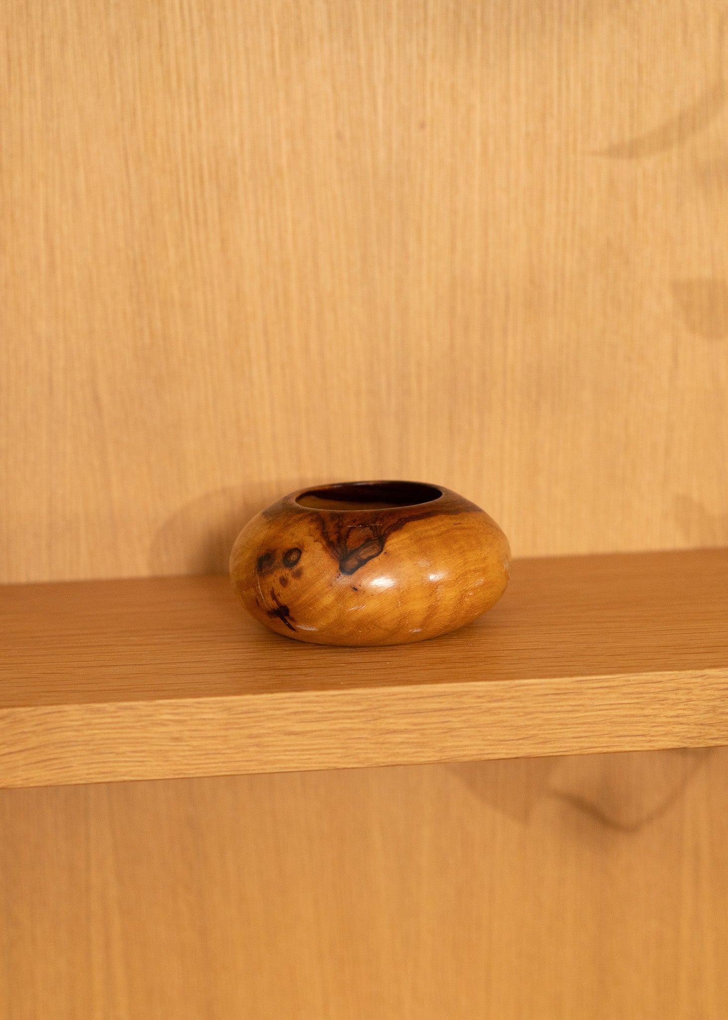 vintage wooden bowl on a wooden shelf against a wooden wall