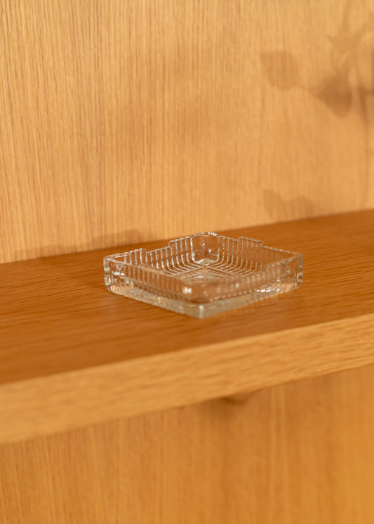 Clear glass vintage square dish on a wooden surface