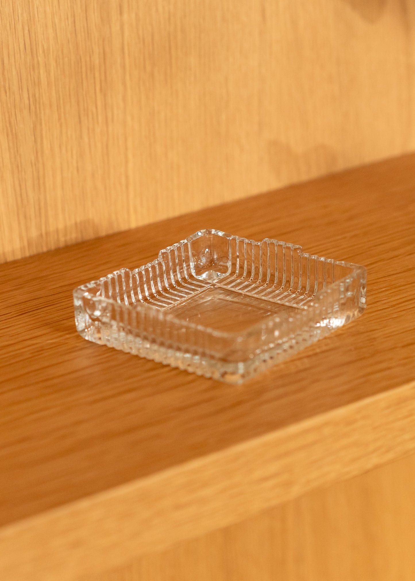 Clear glass vintage ashtray on a wooden surface