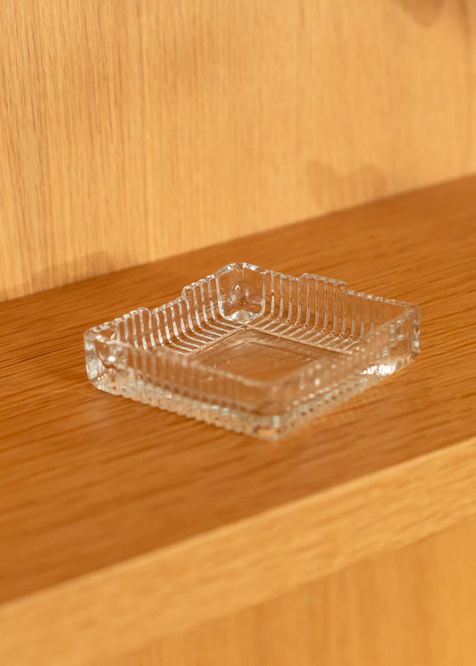 Clear glass vintage ashtray on a wooden surface