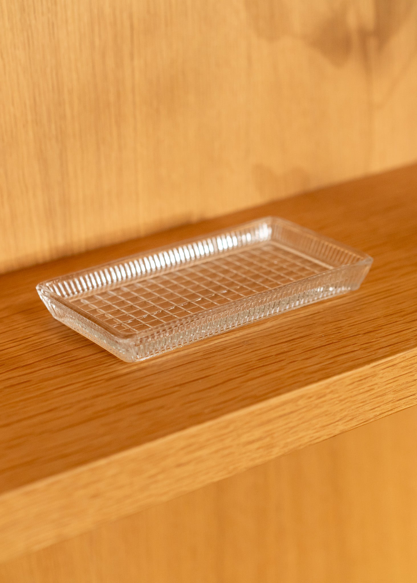Clear vintage glass grid tray on a wooden surface