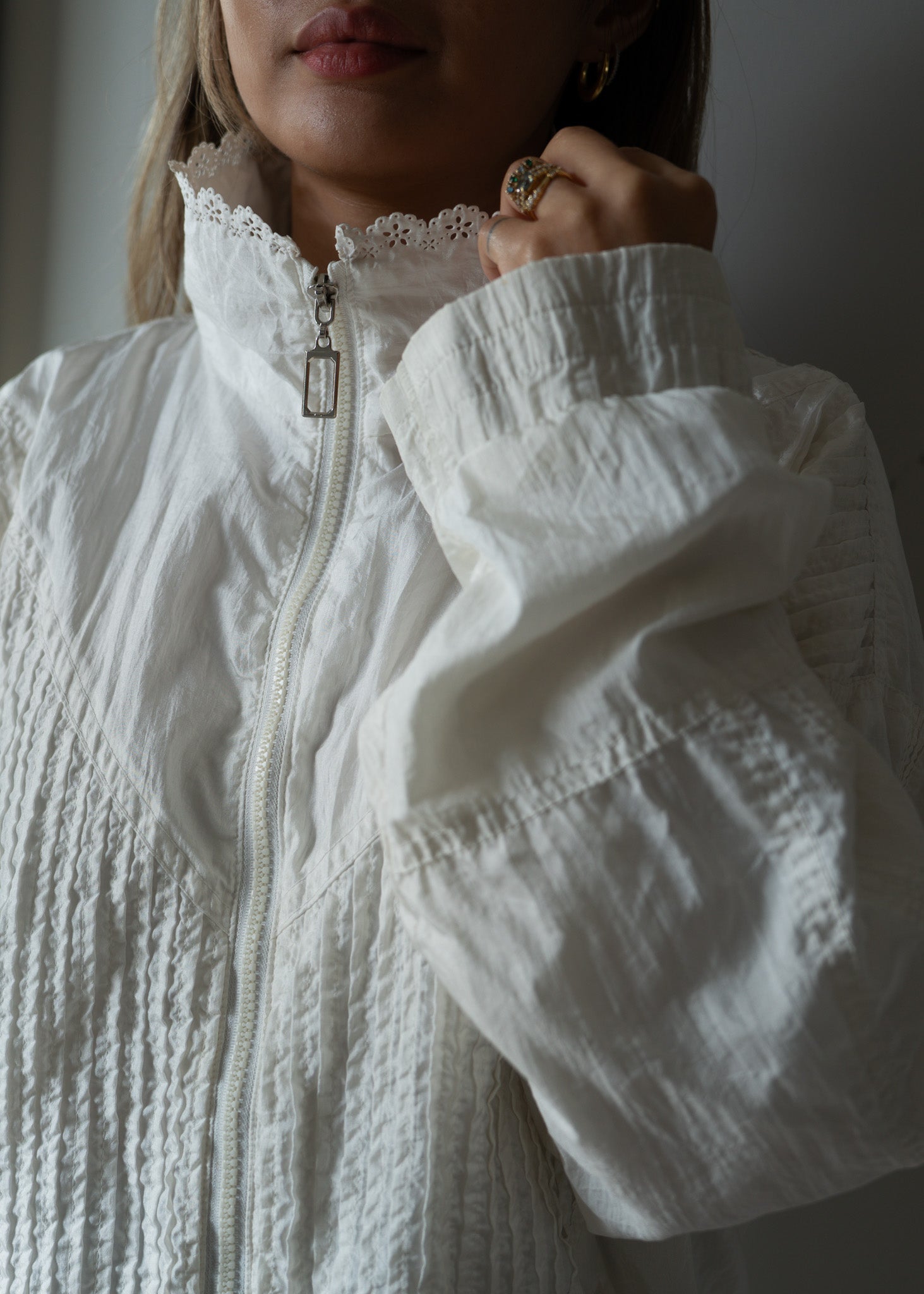 Close-up of a person wearing a textured white jacket with a blurred background