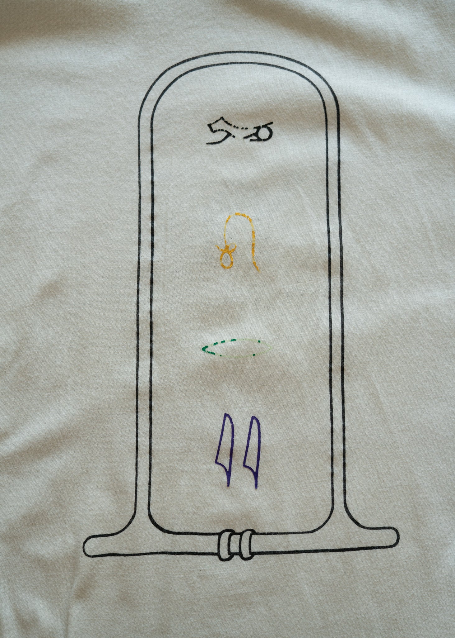 graphic design of Egyptian hieroglyphs on a white fabric background