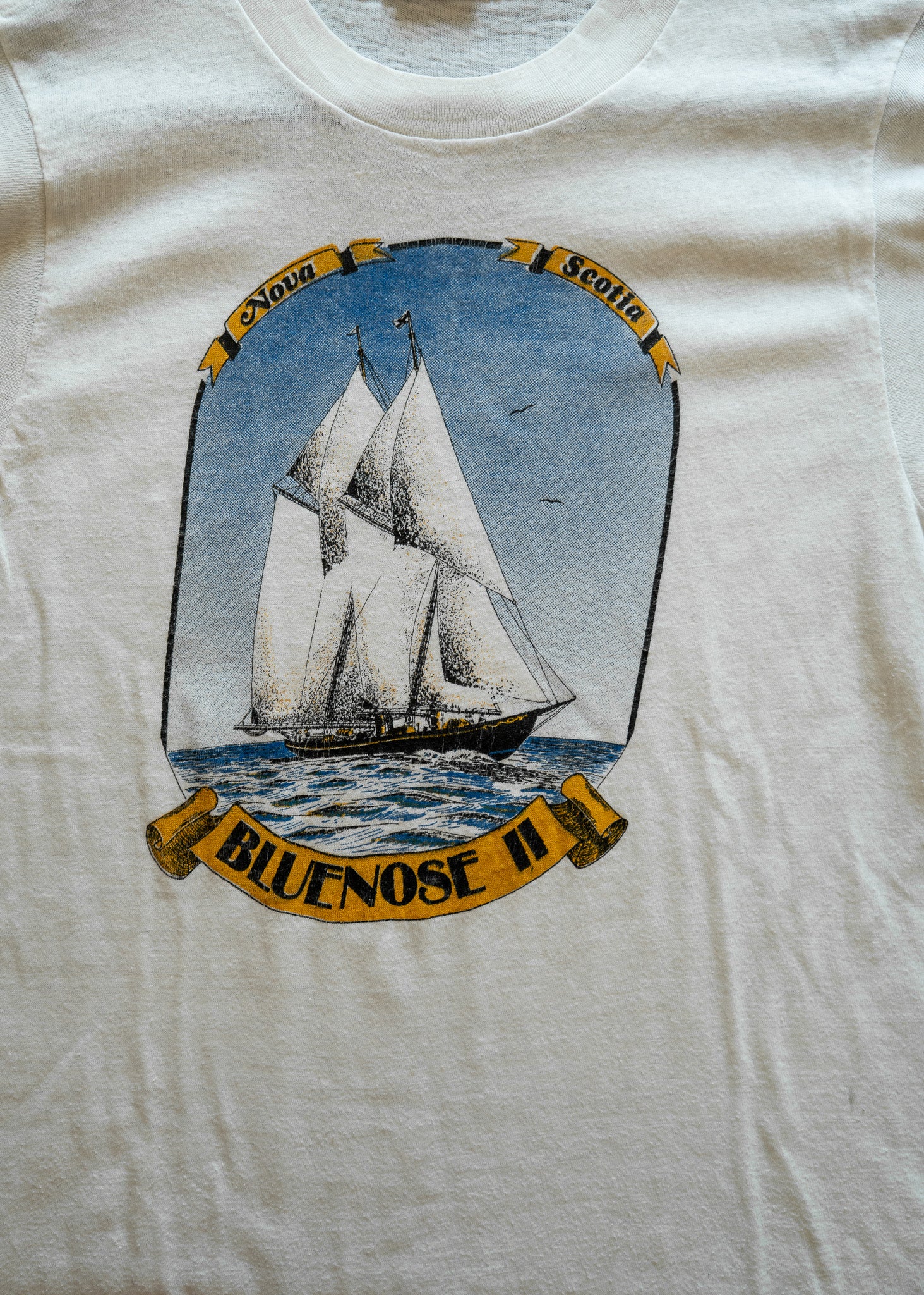 White t-shirt with a sailboat graphic and 'Bluenose II' text on a white background