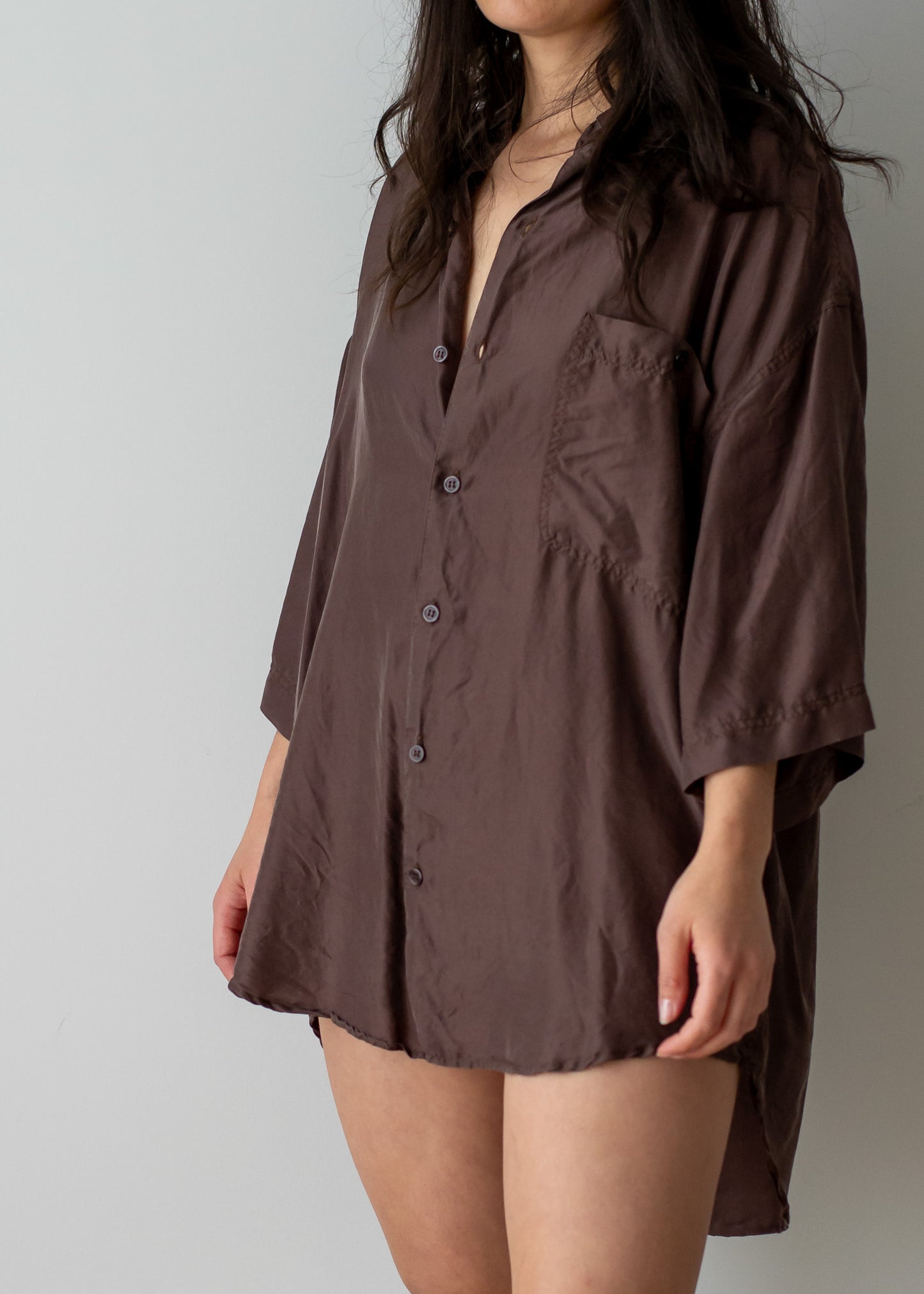 Brown silk button-up shirt worn by a person on a plain background