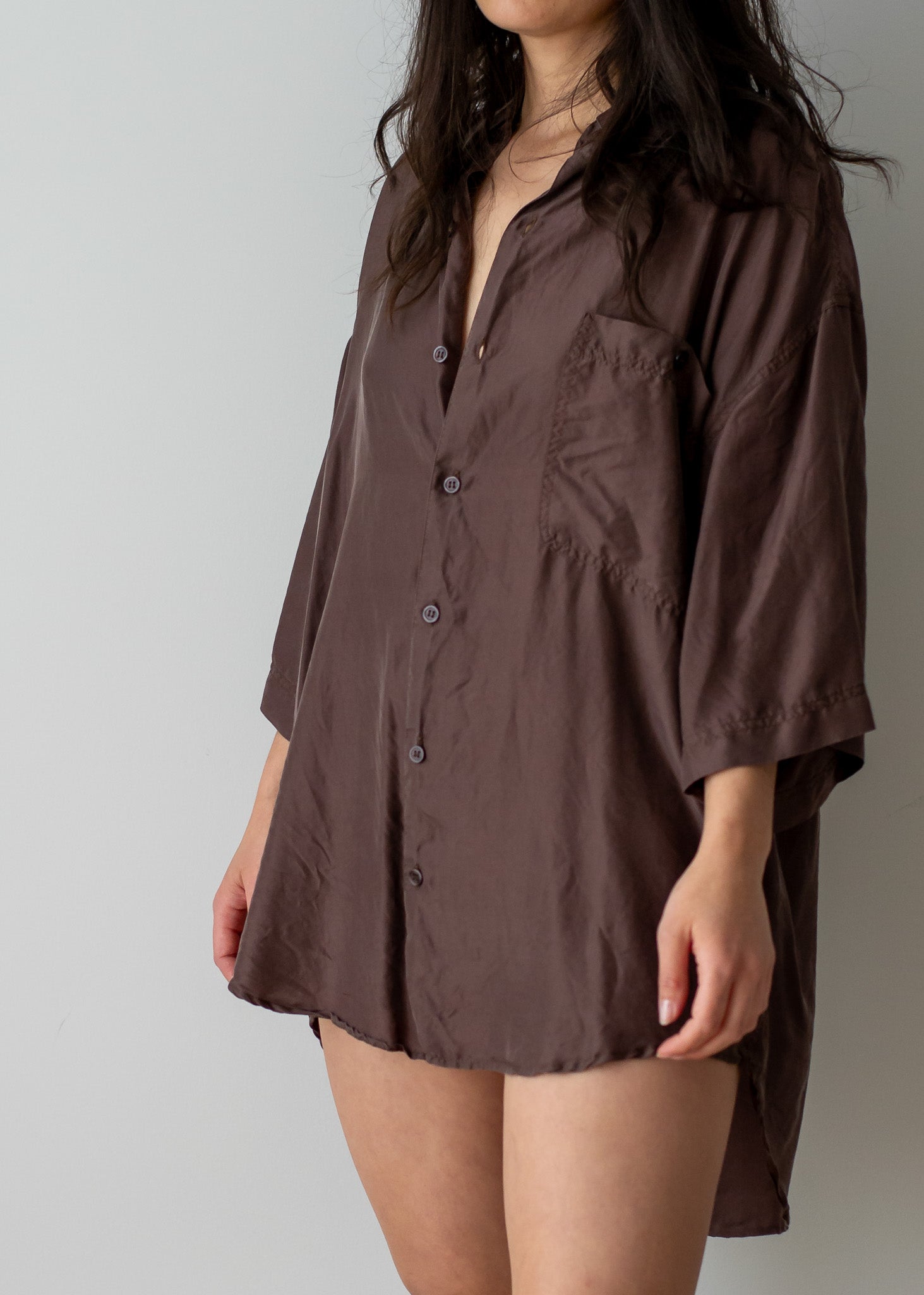 Brown silk button-up shirt worn by a person on a plain background